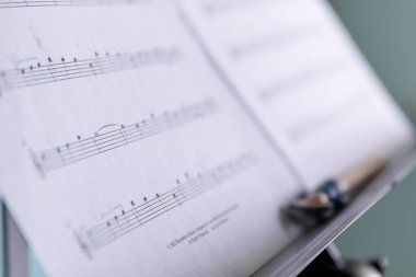 Brecht, Belçika - 15 Nisan 2020: Üzerinde notalar olan bir nota kağıdının yakın plan portresi. Ayrıca kürsüde müzik parçasının notalarının belli noktalarını işaretlemek için bir kalem var..