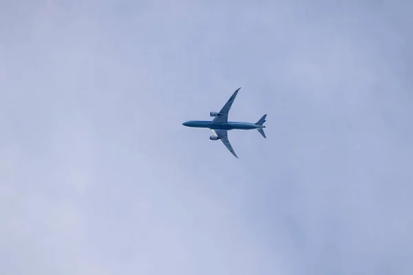 空高く空を飛ぶ民間航空機の肖像画 旅客機の腹が見える — ストック写真