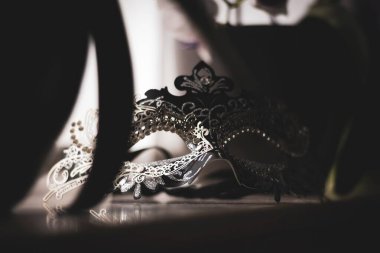 Pencere kenarında duran maskeli bir Venedik maskesinin portresi maskeli baloya ya da cadılar bayramı partisine gitmeye hazır.. 