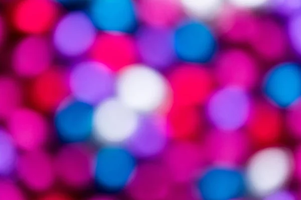An abstact colorful blurry background of different colors. The bokeh balls are pink, red, purple, white and blue.