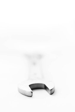 Beyaz bir arka planda duran çift uçlu İngiliz anahtarının siyah beyaz bir portresi. Kafası doğrudan kameraya dönük..