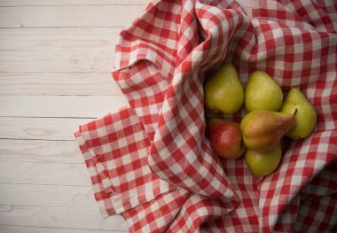 Damalı kumaş üzerinde taze sarı armutlar