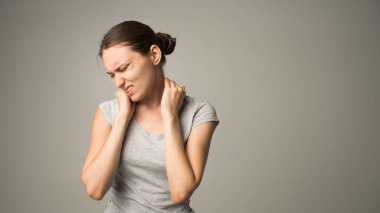 Yorgun kadın acı çekiyor, gergin kaslara masaj yapıyor.