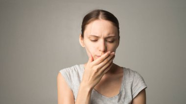 Yorgun bir kadın dişlerinde ağrı hisseder.
