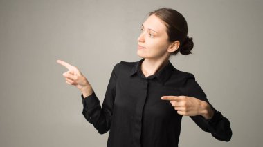 Kadın parmaklarını bir şeye doğrultuyor.