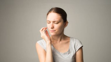 Yorgun bir kadın dişlerinde ağrı hisseder.