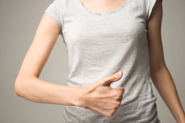 Genç ve güzel bir kadın karnını tutuyor. Karın ağrısı.