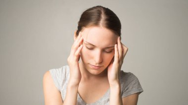 Genç ve güzel bir kadın baş ağrısı çekiyor.