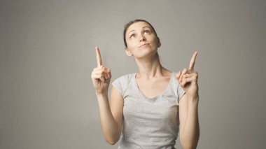 Genç kadın bir şey gösteriyor.