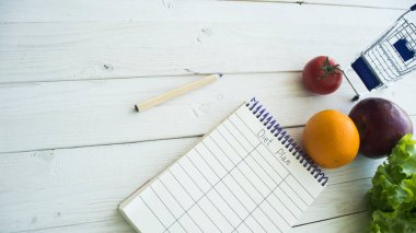 Sağlıklı gıda konsepti için kopyalama alanı olan diyet planı defteri ve sebzeler