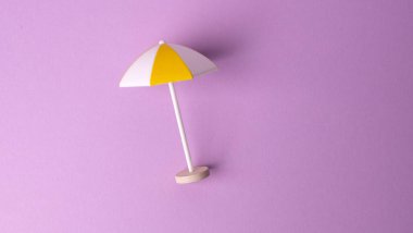 Pembe arka planda çok renkli plaj şemsiyesi