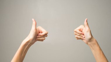 Genç bayan mutlu görünüyor, gülümsüyor, el kol hareketi yapıyor, tamam işareti gösteriyor. Beyaz kadın parmaklarıyla iyi niyet gösterisi yapıyor. Vücut dili kavramı