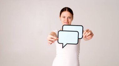 Elinde konuşma balonu tutan genç bir kadın. 