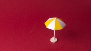 Kırmızı arkaplanda renkli plaj şemsiyesi