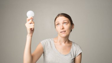 Genç, güzel, siyah saçlı, ampullü bir kadın.