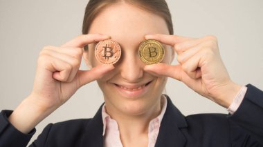 İş kadını elinde bir bitcoin kripto para tutuyor.