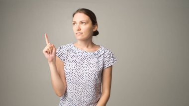 Genç kadın bir şey gösteriyor.