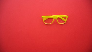 Kırmızı arkaplanda sarı gözlük