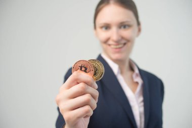 İş kadını elinde bir bitcoin kripto para tutuyor.