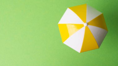 Sarı arka planda çok renkli plaj şemsiyesi