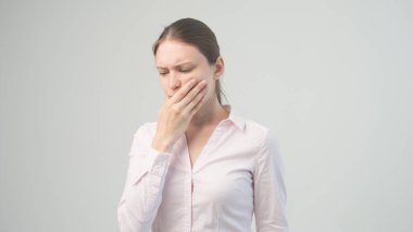 Yorgun bir kadın dişlerinde ağrı hisseder.