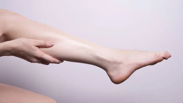 massage of leg muscles with hands, leg pain
