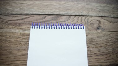 Kahverengi ahşap masa arkaplanındaki boş kağıt defter. Kopyalama alanı olan üst görünüm (seçici odak). Ofis masası konsepti