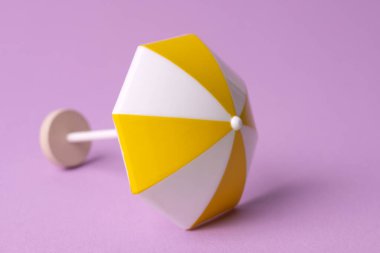 Pembe arka planda çok renkli plaj şemsiyesi