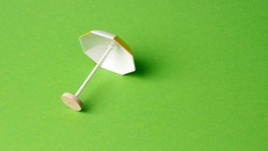 Sarı arka planda çok renkli plaj şemsiyesi