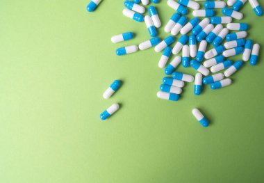 Yeşil arka planda beyaz ve mavi haplar