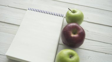 Tahta masada boş küçük defterli yiyecek ürünleri.