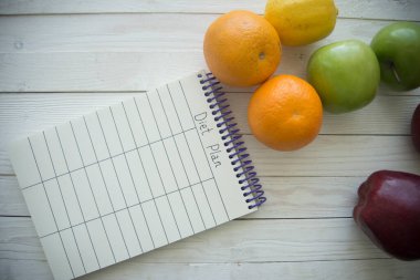 Tahta masada boş küçük defterli yiyecek ürünleri.
