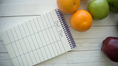 Tahta masada boş küçük defterli yiyecek ürünleri.