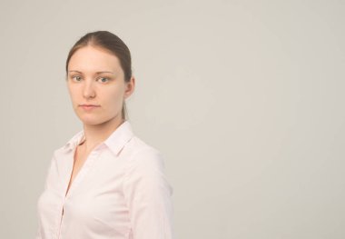 Kameraya bakıp gülümseyen güzel, neşeli bir kızın portresi.