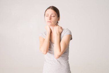 Yorgun kadın boyun ağrısı çekiyor, gergin kaslara masaj yapıyor.