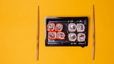 small portion of rolls with fish on an orange background