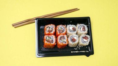 small portion of rolls with fish on an orange background