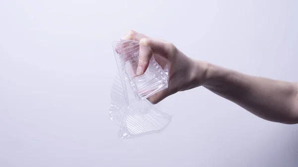 Weibliche Hand Zerknüllt Transparente Kunststoffverpackung Auf Grauem Hintergrund — Stockfoto