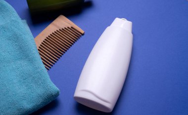 Bir şişe şampuan ya da saç kremi, mavi arka planda.