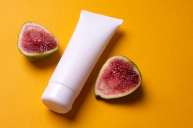 Sarı arka planda el ya da yüz kremi paketleme