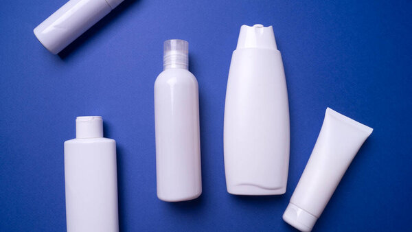 various plastic packaging for shampoo and cream on a blue background