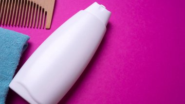 Bir şişe şampuan ya da saç kremi, pembe arka planda.