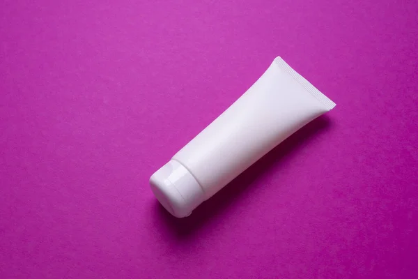 Pembe arka planda el ya da yüz kremi paketleme