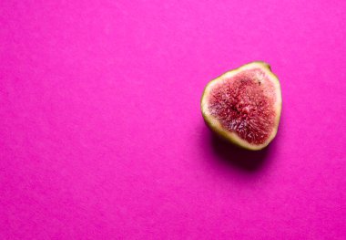 Pembe arka planda yarım olgun incir