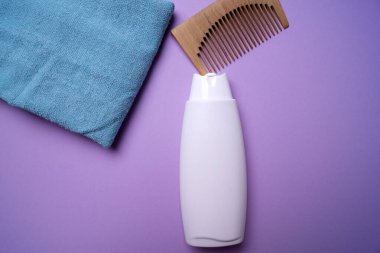 Bir şişe şampuan ya da saç kremi, pembe arka planda.