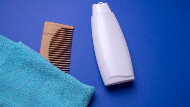 Bir şişe şampuan ya da saç kremi, mavi arka planda.