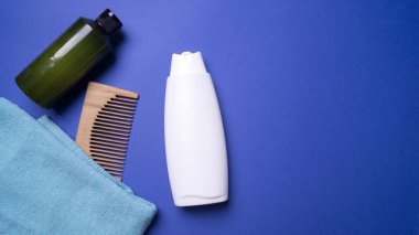 Bir şişe şampuan ya da saç kremi, mavi arka planda.