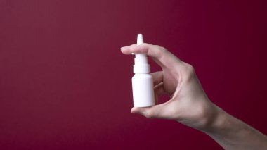 Kadın eli burun spreyi tutuyor.