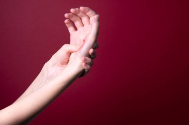 Kadın, ürpertici acıya karşı ellerine masaj yapıyor.