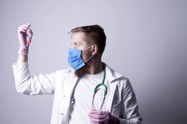 マスクの若い医者がインスリン注射器を持っていて — ストック写真